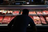 A customer looks at cuts of meat at a butcher shop in Manhattan, New York City