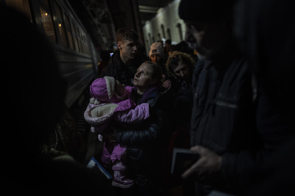 Displaced Ukrainians wait to board a Poland bound train in Lviv, western Ukraine, Sunday, March 13, 2022. Lviv in western Ukraine itself so far has been spared the scale of destruction unfolding to its east and south. The city's population of 721,000 has swelled during the war with residents escaping bombarded population centers and as a waystation for the nearly 2.6 million people who have fled the country. (AP Photo/Bernat Armangue)