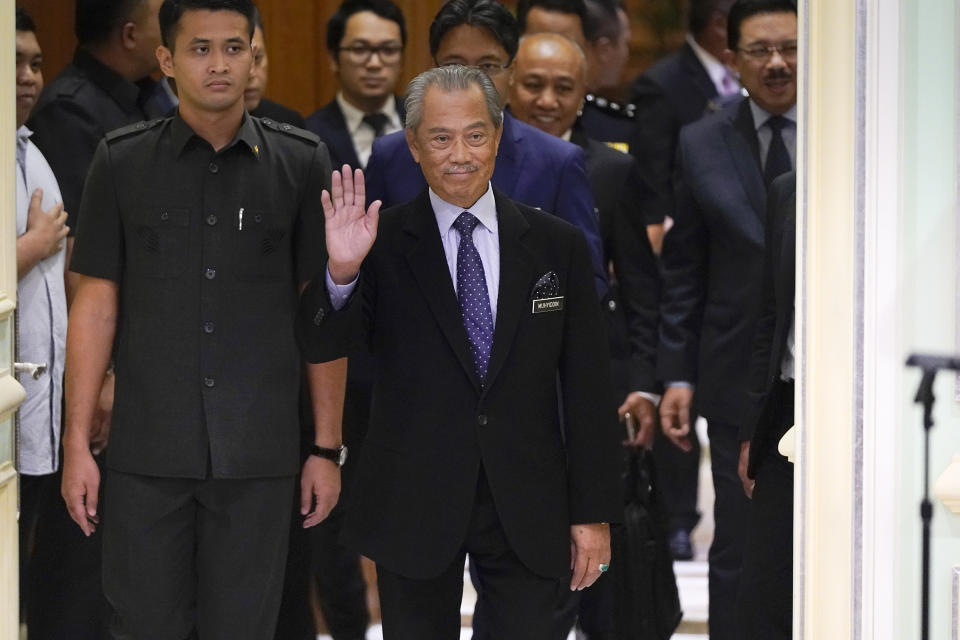 Malaysia's new prime minister, Muhyiddin Yassin, waves as he arrives for a press conference at the prime minister's office in Putrajaya, Malaysia, Monday, March 9, 2020. Muhyiddin unveiled his cabinet on Monday, saying he will have no deputy but will instead appoint four senior ministers in the move that helped him dodge the tricky issue of succession in his Malay0majority government. (AP Photo/Vincent Thian)