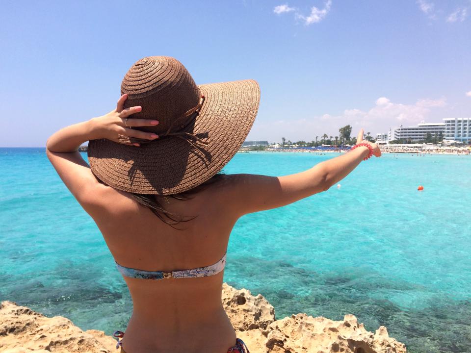 A woman pointing at a beach at Ayia Napa, Cyprus.