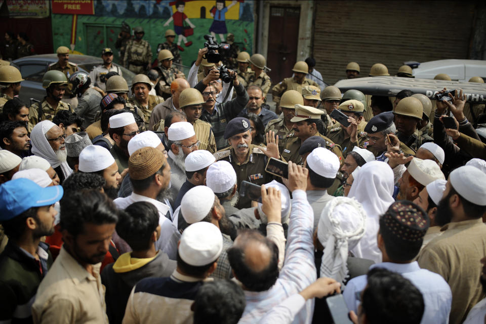 A senior Delhi police officer speaks to a group of Muslims ahead of Friday prayers in New Delhi, India, Friday, Feb. 28, 2020. Muslims returned to the battle-torn streets of northeastern New Delhi for weekly prayers at heavily-policed fire-bombed mosques on Friday, two days after a 72-hour clash between Hindus and Muslims that left at least 38 dead and hundreds injured. (AP Photo/Altaf Qadri)