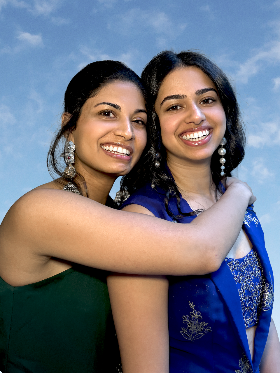 sisters and sani designers niki and ritika shamdasani hug each other in a headshot