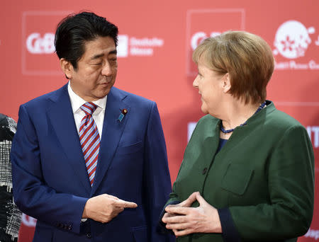 German Chancellor Angela Merkel and Japanese Prime Minister Shinzo Abe attend the opening ceremony of the CeBit computer fair, which will open its doors to the public on March 20, at the fairground in Hanover, Germany, March 19, 2017. REUTERS/Fabian Bimmer