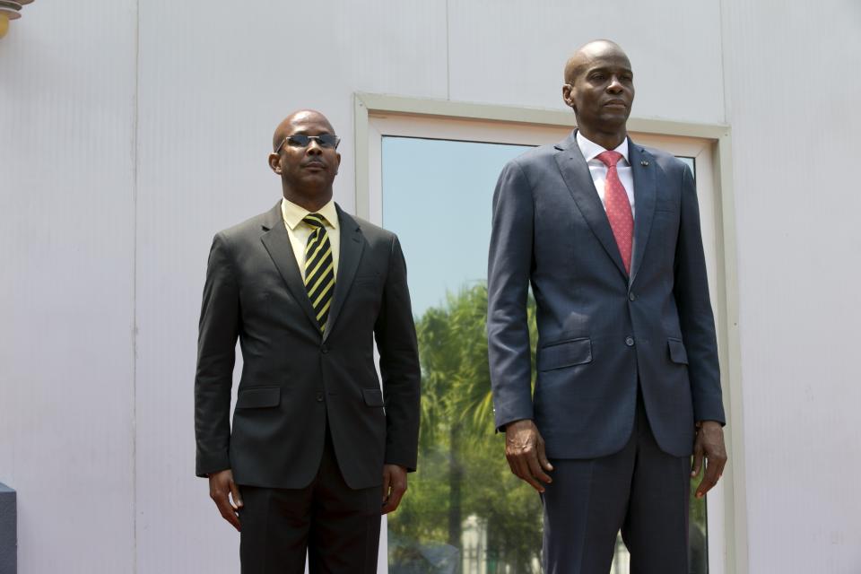 Haiti's President Jovenel Moise stands with the newly-named interim Prime Minister Jean Michel Lapin, during the national anthem at the minister's presentation ceremony in Port-au-Prince, Haiti, Thursday, March 21, 2019. Moise's allies in the lower house of Parliament dissolved the Haitian government by dismissing Prime Minister Jean-Henry Ceant on Monday hours before he was due to testify in the Senate about the case regarding a group of American contractors who were sent to Haiti on a mission to protect a businessman signing a more than $50 million contract at the country's central bank. (AP Photo/Dieu Nalio Chery)