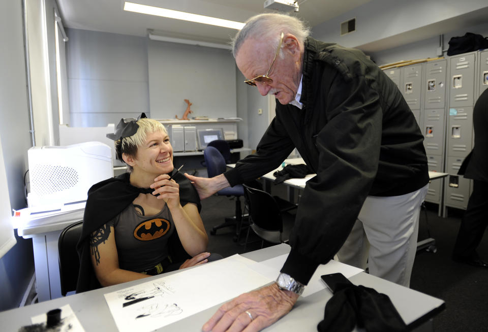 Legendary comic creator Stan Lee, right, looks over a drawing by Savannah College of Art and Design sequential art student Jen Hickman while visiting the college in Savannah, Ga., on Wednesday, Oct. 31, 2012. Lee, the 89-year-old co-creator of Spider-Man, dropped in on the school after being honored at the SCAD Savannah Film Festival. (AP Photo/Stephen Morton)