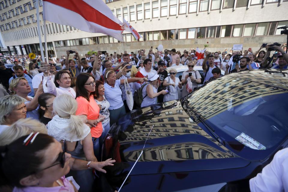 People block a car carrying Uladzimir Karanik, Minister of Health of the Republic of Belarus during a rally in Minsk, Belarus, Monday, Aug. 17, 2020. Workers heckled and jeered President Alexander Lukashenko on Monday as he visited a factory and strikes grew across Belarus, raising the pressure on the authoritarian leader to step down after 26 years in power. (AP Photo/Sergei Grits)