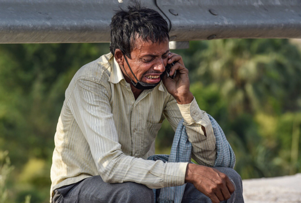 Rampukar Pandit cries while clutching a phone in Delhi, India. 