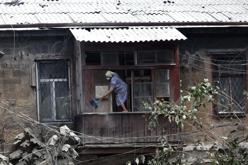 A local resident cleans her balcony the day after a military strike in the center of Odesa (AFP via Getty Images)