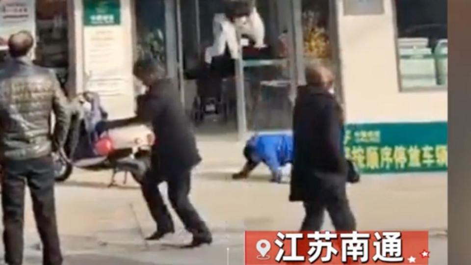 身穿藍衣的路人男子飛撲到地上充當墜樓少女的「肉墊」，成功救回少女一命。（圖／翻攝自微博）