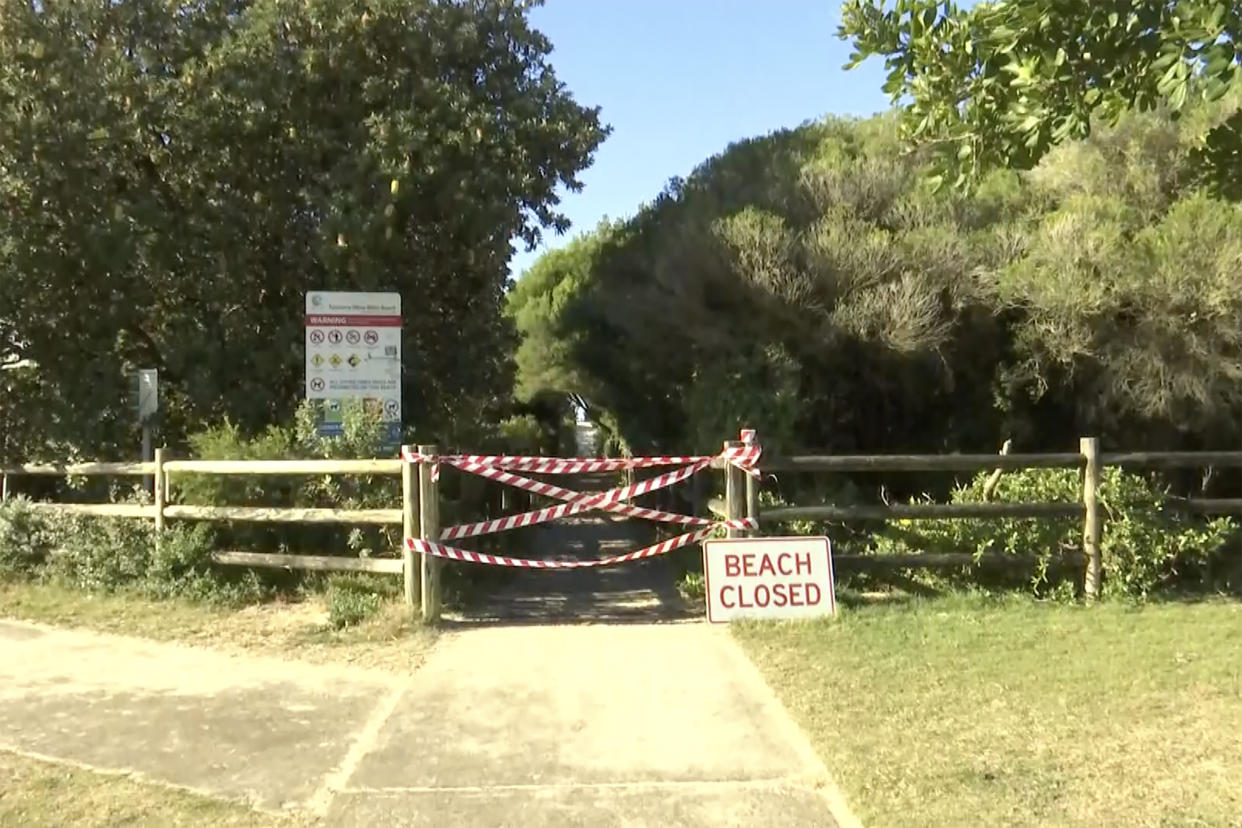 This image made from a video, shows a beach closed sign in Tuncurry, Australia Tuesday, May 18, 2021. A surfer was killed by a shark on Tuesday, police said. The man, aged in his 50s, had been surfing off Forster, 220 kilometers (137 miles) north of Sydney,  when he was attacked late in the morning, a police statement said. (Australian Broadcasting Corporation via AP)