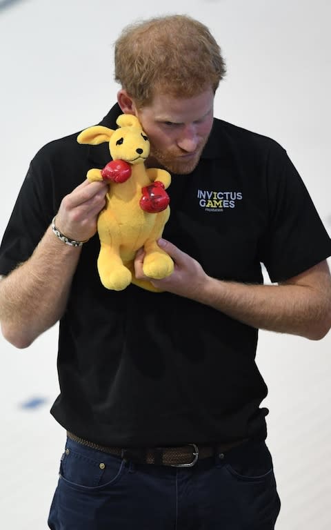 Prince Harry holding a Kangaroo presented to him by the Australian basketball team