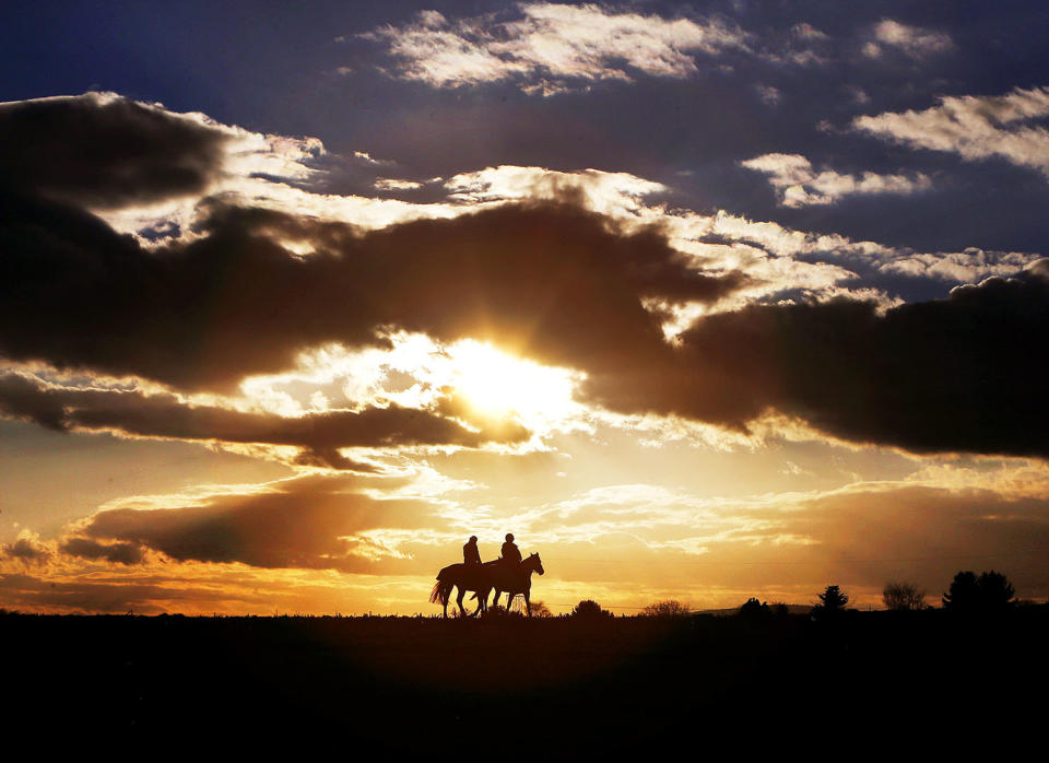 <p>Two women ride their horses on a small road between acres and fields as the sun sets in Oberursel, Germany, Friday, Feb. 24, 2017. (Photo: Michael Probst/AP) </p>