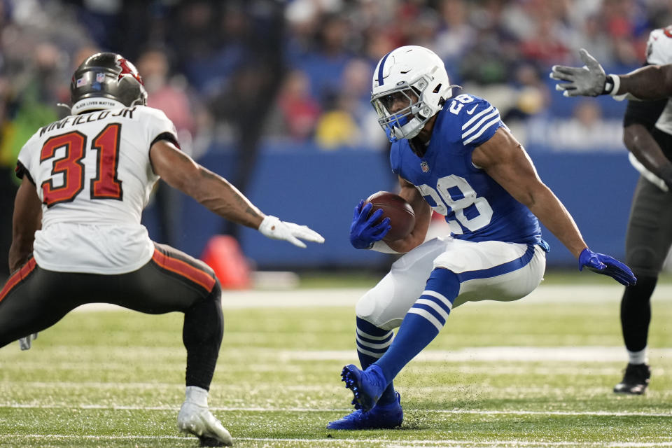 Indianapolis Colts' Jonathan Taylor (28) runs against Tampa Bay Buccaneers' Antoine Winfield Jr. (31) during the first half of an NFL football game, Sunday, Nov. 28, 2021, in Indianapolis. (AP Photo/AJ Mast)