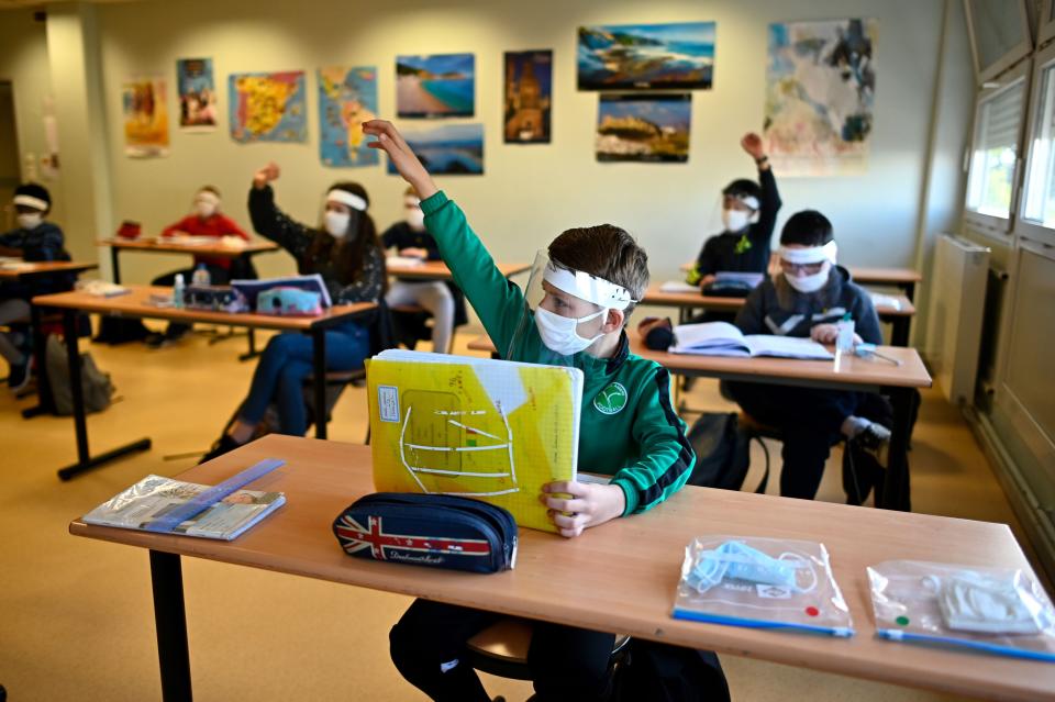 Schoolchildren wearing protective masks and face shields in a classroom at Claude Debussy college in Angers, France, on May 18 after France eased lockdown measures to curb the spread of the COVID-19.