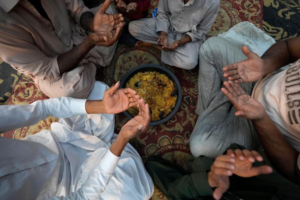 People pray before breaking their fast during the Muslim's holy fasting month of Ramadan in Karachi, Pakistan. (Associated Press - image credit)