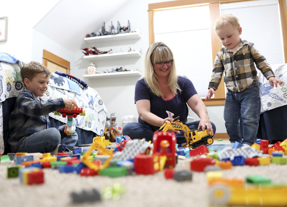 Karli Neilson plays legos with her sons Ezra, 5, left, and Axel, 2, in Gearhart, Ore., Friday, Sept. 2, 2022. Neilson has alternated between having to take time off work and working part-time so as to watch her 2-year-old son. She hasn't been able to find formal care for him since he was born in August 2020. (AP Photo/Craig Mitchelldyer)