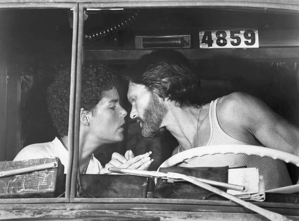 Truck driver Rubber Duck (Kris Kristofferson) and photojournalist Melissa (Ali MacGraw) lean in to kiss in Rubber Duck's cab in a scene from the 1978 film Convoy.