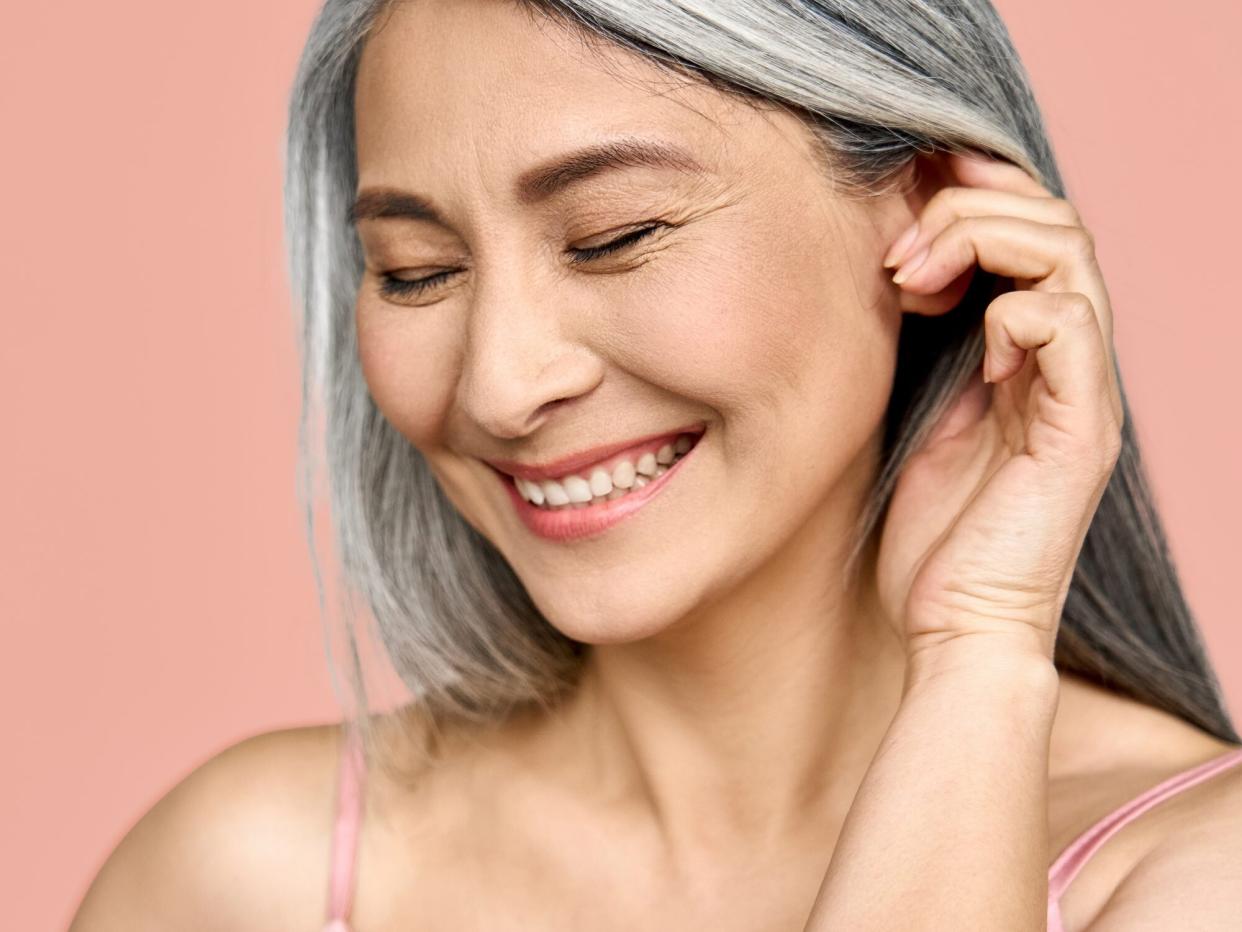 happy middle aged mature asian woman headshot portrait.