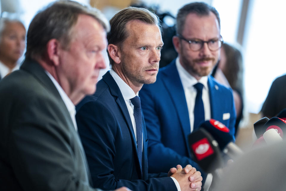 From left, Minister of Foreign Affairs Lars Loekke Rasmussen, Minister of Justice Peter Hummelgaard and Deputy Prime Minister Jakob Ellemann-Jensen present a bill on a Quran burning ban on a doorstep in Christiansborg, Copenhagen, Friday, Aug. 25, 2023. (Martin Sylvest/Ritzau Scanpix via AP)