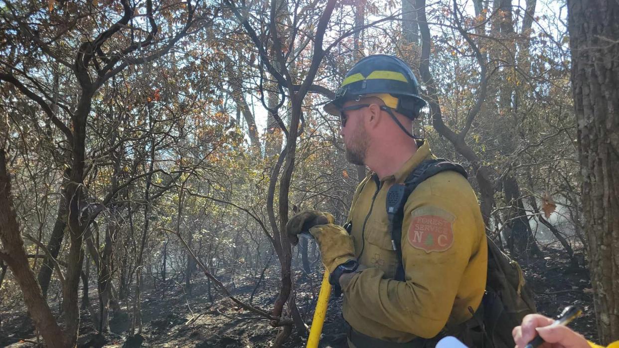 David Poole, the North Carolina Forest Service division supervisor, watches as the ground smolders at the Poplar Drive Fire on Nov. 8.
