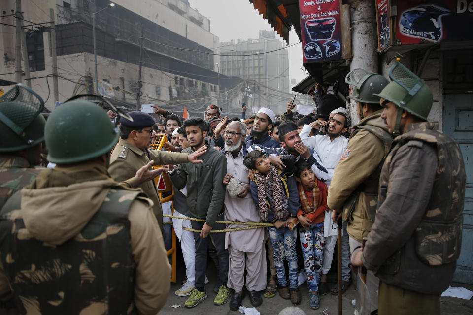 Indian policemen stop protesters at a police barricade in New Delhi, India, Friday, Dec. 20, 2019. Police banned public gatherings in parts of the Indian capital and other cities for a third day Friday and cut internet services to try to stop growing protests against a new citizenship law that have so far left more than 10 people dead and more than 4,000 others detained. (AP Photo/Altaf Qadri)