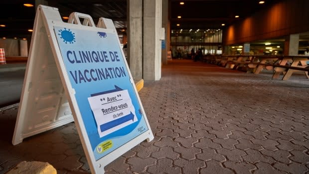 A sign for a COVID-19 vaccine clinic at the Palais des Congrès de Gatineau in April 2021. A delayed delivery of Pfizer vaccine doses has forced western Quebec's health authority to temporarily halt online appointment bookings. (David Richard/Radio-Canada - image credit)