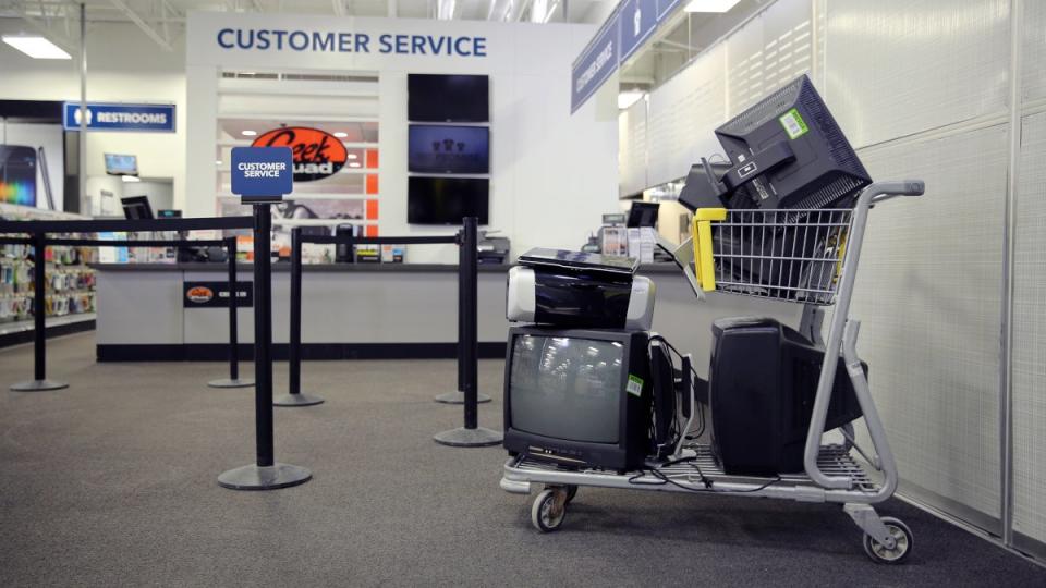 A cart near the customer service line in Best Buy filled with old TVs.