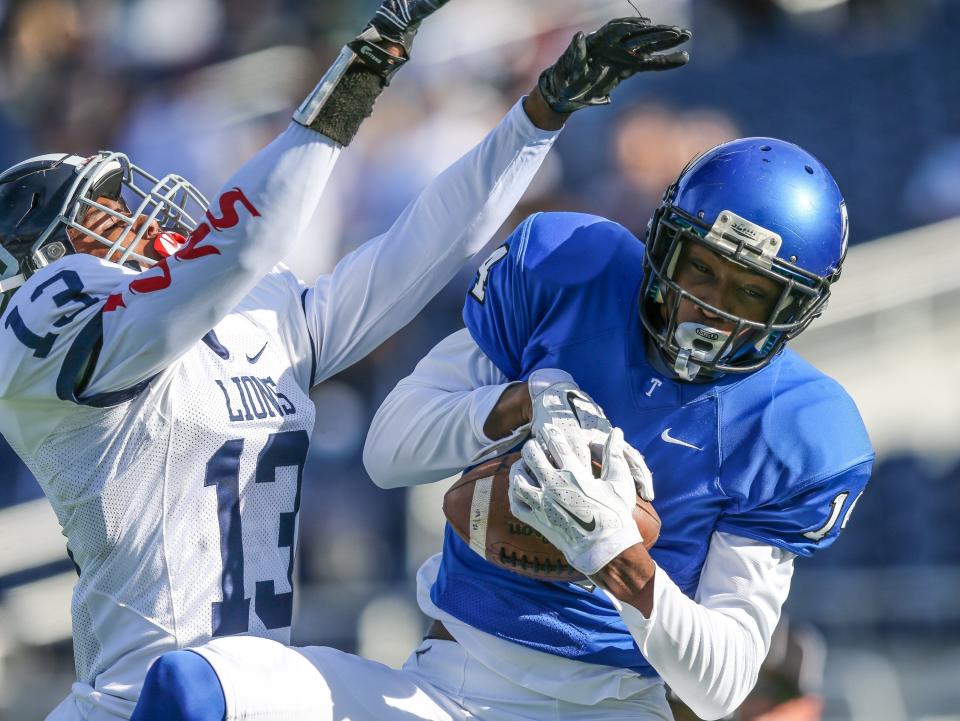 Trinity Christian wide receiver Isaiah Washington (14) catches a pass in the end zone for a touchdown defended by Chaminade-Madonna's Bradley Royas (13) during the first half of the FHSAA Class 3A football final in 2016.