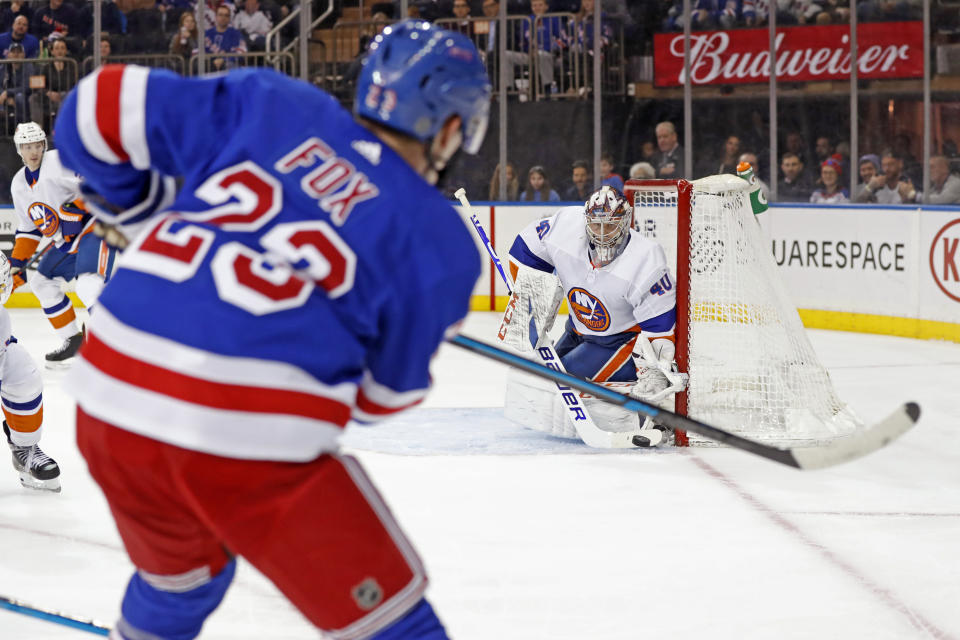 New York Rangers defenseman Adam Fox (23) shoots against New York Islanders goaltender Semyon Varlamov (40) who appears to stop the puck, but doesn't as Fox scored during the second period of an NHL hockey game, Monday, Jan. 13, 2020, in New York. (AP Photo/Kathy Willens)