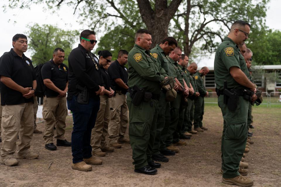 U.S. Border Patrol agents pray during their visit to a memorial at Robb Elementary School in Uvalde, Texas, Tuesday, May 31, 2022, to honor the victims killed in last week's school shooting. (AP Photo/Jae C. Hong) ORG XMIT: TXJH114