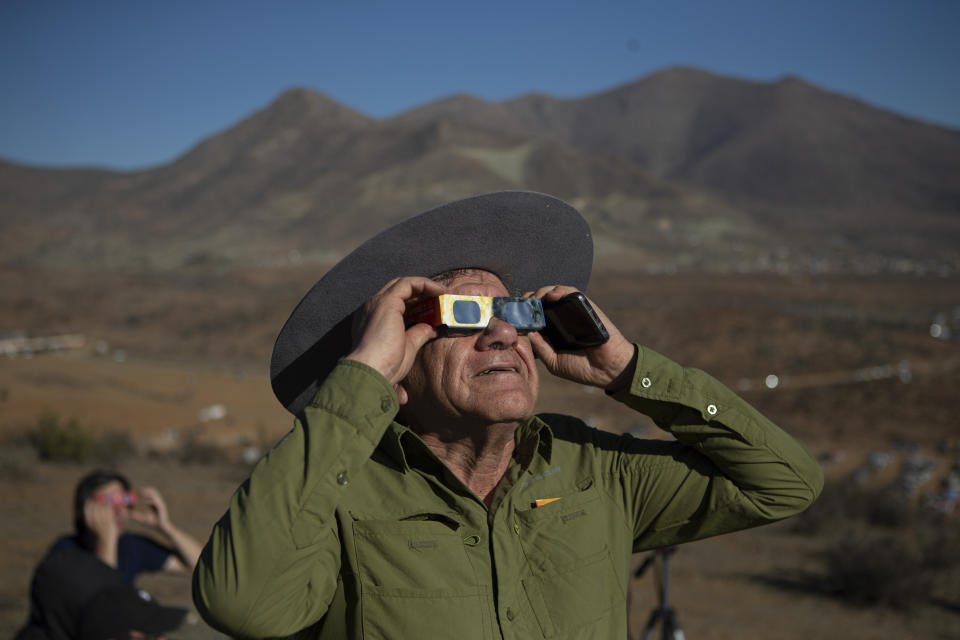 A man looks up at a total solar eclipse in La Higuera, Chile, Tuesday, July 2, 2019. Northern Chile is known for clear skies and some of the largest, most powerful telescopes on Earth are being built in the area, turning the South American country into a global astronomy hub. (AP Photo/Esteban Felix)