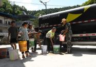 Villagers line up to receive water amid hot temperatures in Chongqing