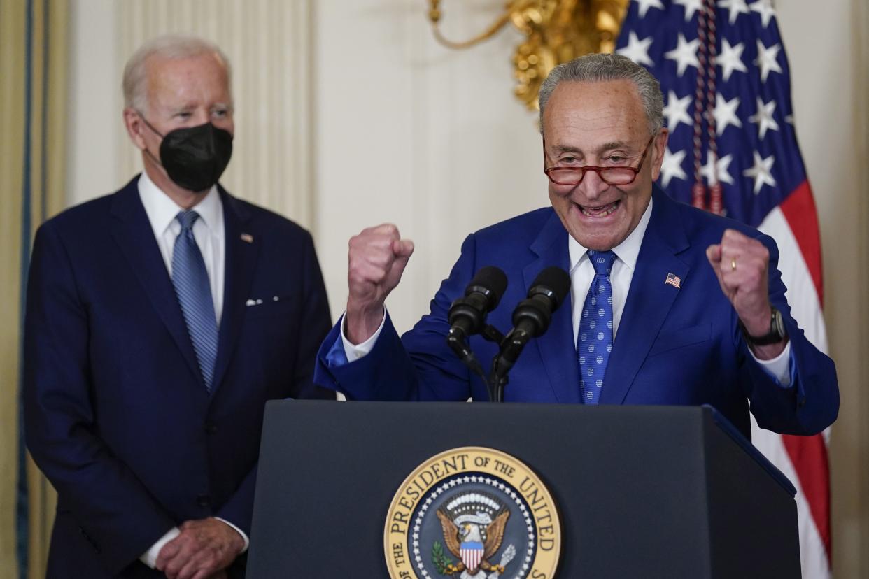 President Joe Biden listens as Senate Majority Leader Chuck Schumer of N.Y., speaks before Biden signs the Democrats' landmark climate change and health care bill in the State Dining Room of the White House in Washington, Tuesday, Aug. 16, 2022.