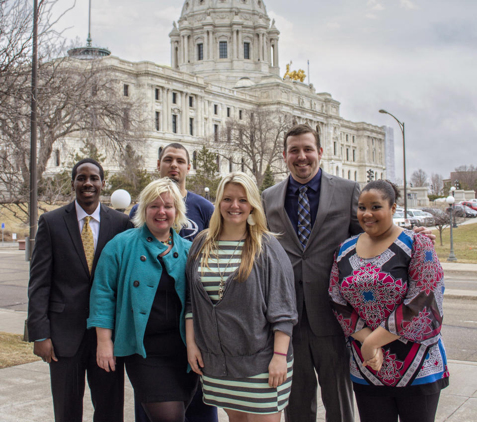 In this April 3, 2014 photo provided by Concordia University, from left: Akolade Gdadamosi; professor Jayne Jones; Chris Ploch; Hope Baker; Adam Goinz and Jordan Strickland pose for a photo outside the Minnesota State Capitol in St. Paul, Minn. Jones and the political science students said they became convinced by what they heard from lawmakers and police during their research for a political science project that some legislators had abused their state-issued immunity cards to get away with driving drunk. Their proposal to lift the privilege won committee approvals in 2012 but failed to get floor votes. So Jones said her class decided to try again this year and were taken by surprise when they learned they were getting a vote. (AP Photo/Concordia University, Melissa Wolf)