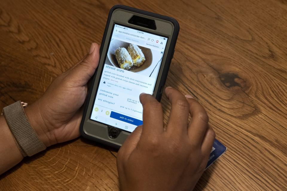 A diner at Bartaco uses their app to order an item off the menu, at the restaurant in Arlington, Va., on Thursday, Sept. 2, 2021. The restaurant is using an automated app for ordering and payments. Instead of servers they use "food runners" to get the food to the tables. (AP Photo/Jacquelyn Martin)