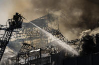 Firefighters work as smoke rises out of the Old Stock Exchange in Copenhagen, Denmark, Tuesday, April 16, 2024. A fire raged through one of Copenhagen’s oldest buildings on Tuesday, causing the collapse of the iconic spire of the 17th-century Old Stock Exchange as passersby rushed to help emergency services save priceless paintings and other valuables. (Emil Nicolai Helms/Ritzau Scanpix via AP)