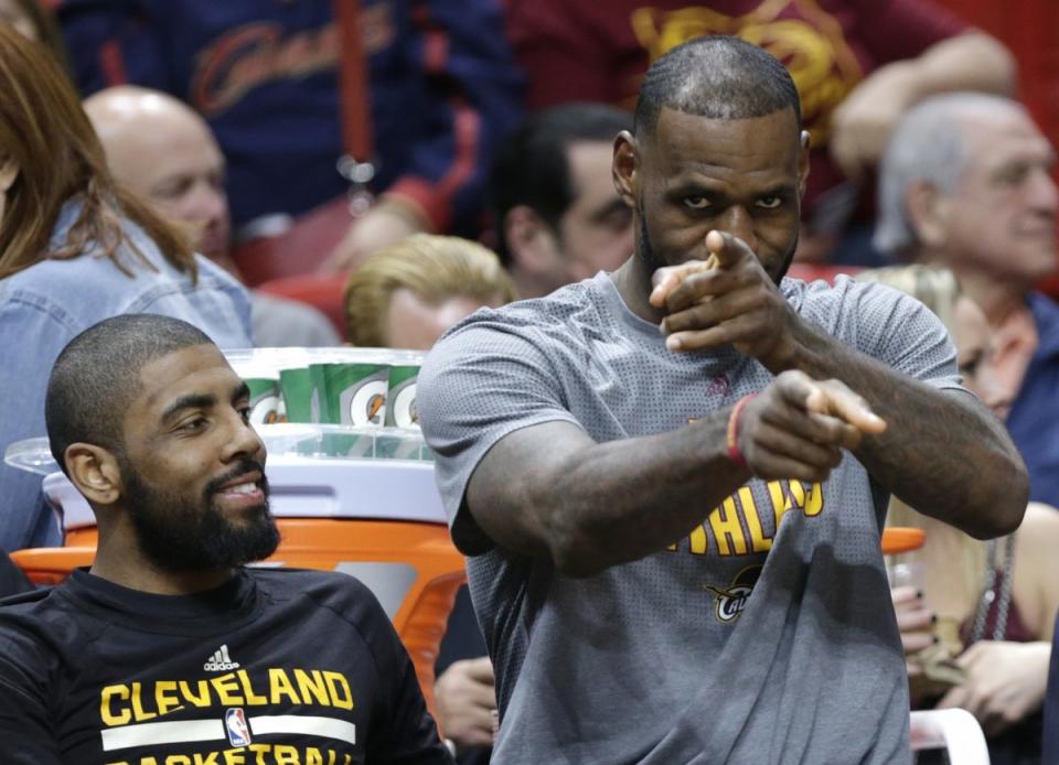 At least LeBron James gets paid to sit in a front-row seat. (AP)