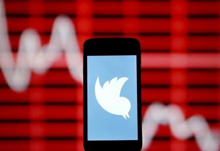 The Twitter logo is shown on smartphone in front of a displayed stock graph in central Bosnian town of Zenica, Bosnia and Herzegovina, in this April 29, 2015 photo illustration. REUTERS/Dado Ruvic