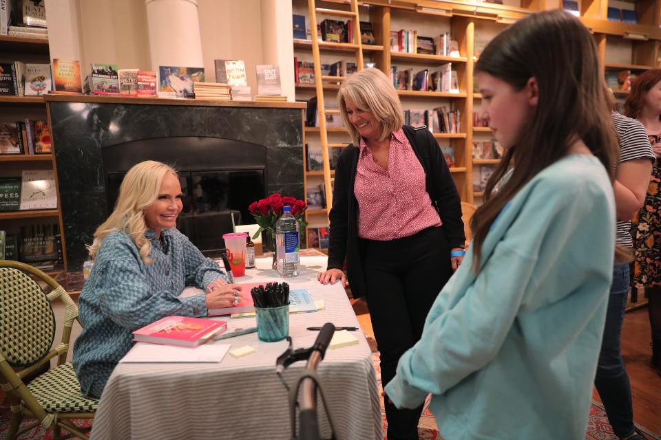 Janet McWilliams and her granddaughter, Addie Wehling, talk Monday with Kristin Chenoweth during a book signing event for Chenoweth's new book at Full Circle Bookstore in Oklahoma City.