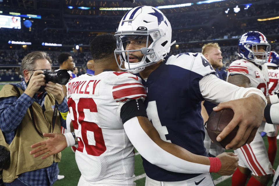 Dallas Cowboys quarterback Dak Prescott (4) hugs New York Giants running back Saquon Barkley (26) after an NFL football game Thursday, Nov. 24, 2022, in Arlington, Texas. The Cowboys won 28-20. (AP Photo/Michael Ainsworth)