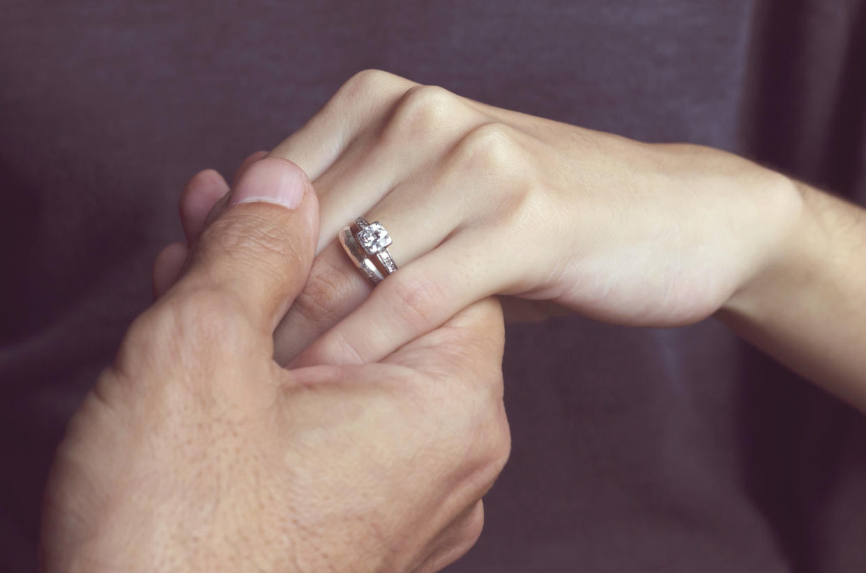 Holding Hands with engagement rings, close-up