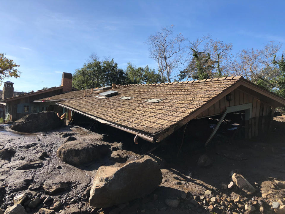 A damaged Montecito house is surrounded by&nbsp;dislodged boulders and debris. (Photo: Mike Eliason/Santa Barbara County Fire Department via Reuters)