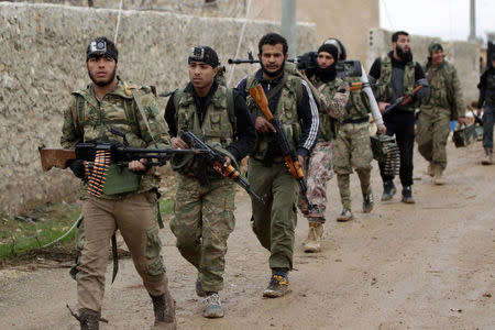 Rebel fighters walk carrying their weapons on the outskirts of the northern Syrian town of al-Bab, Syria January 15, 2017. REUTERS/Khalil Ashawi