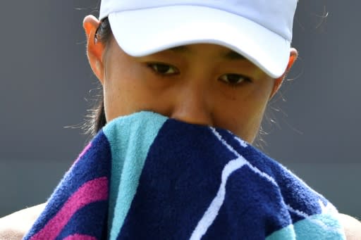 Zhang Shuai wipes her face as she sits in the break between games