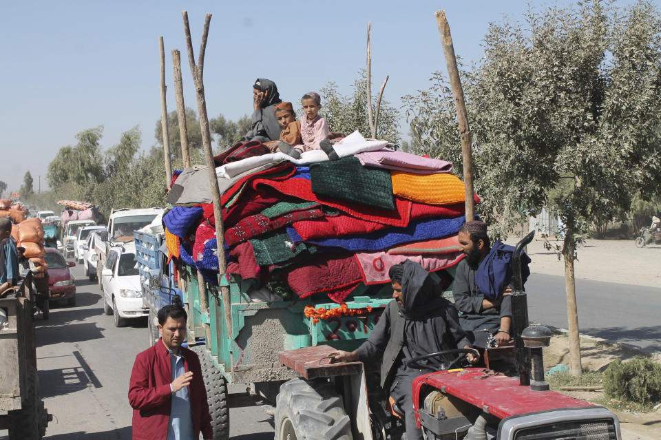 Afghan families leave their houses after fighting between the Afghan military and Taliban insurgents in Helmand province, southern of Afghanistan, Tuesday, Oct. 13, 2020. (AP Photo/Abdul Khaliq)