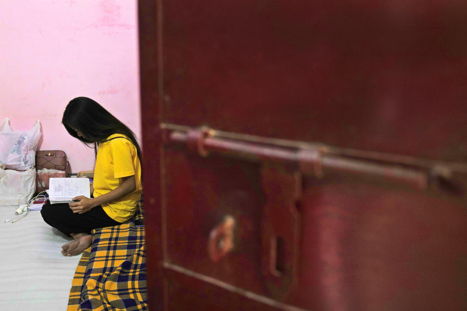 A Myanmar refugee, 26, who fled during the violence of the town of Mindat in Chin state, northwestern Myanmar, reads a book at an undisclosed location, in India, Monday, Dec. 13, 2021. (AP Photo/Manish Swarup)