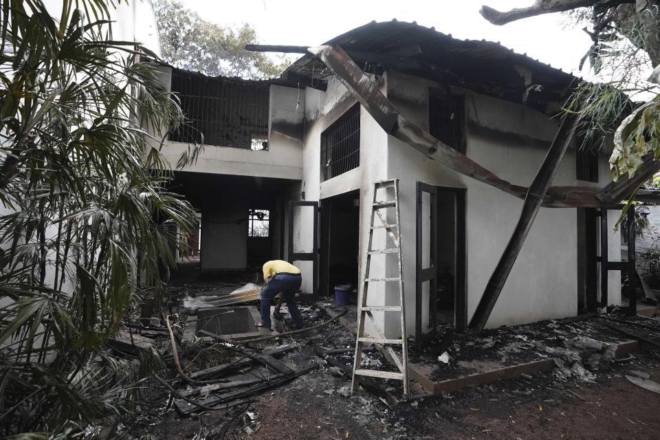 A man checks the debris of the burnt private residence of prime minister Ranil Wickremesinghe in Colombo, Sri Lanka, Sunday, July 10, 2022. Sri Lanka’s president and prime minister agreed to resign Saturday after the country’s most chaotic day in months of political turmoil, with protesters storming both officials’ homes and setting fire to one of the buildings in a rage over the nation's severe economic crisis. (AP Photo/Thilina Kaluthotage)