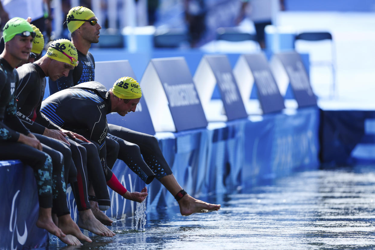 The United State's Carson Clough, far right, prepares to compete in the PTS4 Triathlon at the 2024 Paralympics, Monday, Sept. 2, 2024 in Paris, France. (AP Photo/Caleb Craig)