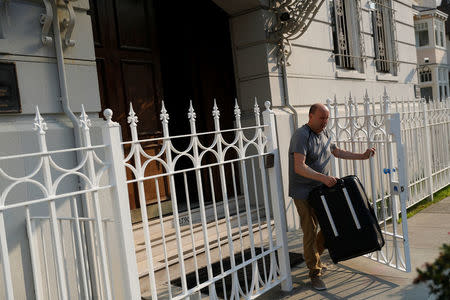 A member of the Consulate General of Russia carries a suitcase out of the consulate in San Francisco, California, U.S., September 2, 2017. REUTERS/Stephen Lam