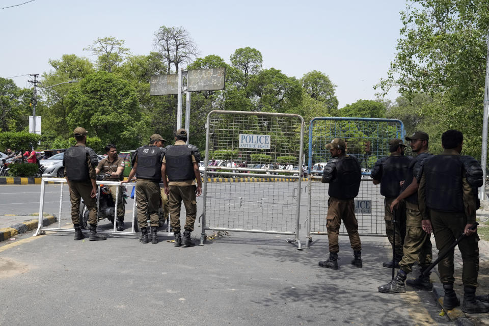 Pakistani security officials close a road outside the former Prime Minister Imran Khan's residence in Lahore, Pakistan, Thursday, May 18, 2023. Pakistani police kept up their siege around the home of Khan as a 24-hour deadline given to the former premier to hand over suspects allegedly sheltered inside was about to expire on Thursday. (AP Photo/K.M. Chaudary)